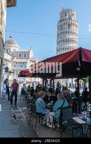 Une caf animée de touristes sur la via Santa Maria en pleine vue du complexe de la Tour penchée sur la Piazza del Duomo à Pise dans la région toscane de l'Italie Banque D'Images