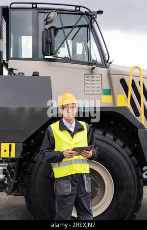 Ingénieur avec tablette se tient à côté du camion minier. Banque D'Images