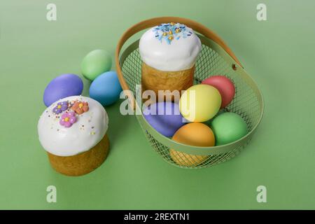Gâteau de Pâques et œufs dans un panier sur fond vert Banque D'Images