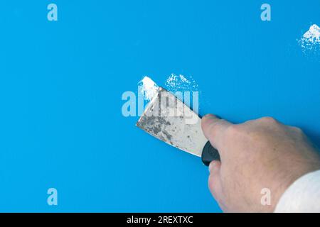 Remplir les petits trous d'ongle ou les rayures profondes avec du plâtre mastic dans le mur avant de peindre. Banque D'Images