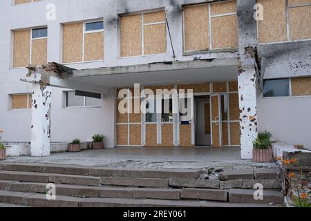 Entrée de l'école dans le village de Stepnohirsk, qui a été directement touché par la roquette. Malgré la contre-offensive ukrainienne actuellement en cours dans la région de Zaporizhzhya et le risque d’une attaque terroriste contre la centrale nucléaire, la vie quotidienne dans la région de Zaporizhzhia continue. Les soirées chaudes remplissent les rues de la ville de gens qui se promènent, tandis que les tournesols fleurissent dans les zones de première ligne et que les premières récoltes ont commencé. Cependant, la guerre intensifiée ne faiblit pas - un bombardement intense presque quotidiennement prend la vie des gens, qui souffrent en outre du manque d'eau après le non Banque D'Images