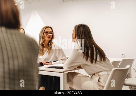 Deux femmes discutaient de stratégies visant à accroître la productivité. Des idées ont été échangées et débattues entre les membres de l'équipe. Banque D'Images