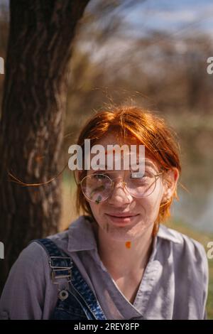 Portrait de belle peintre fille de gingembre souriant et regardant la caméra Banque D'Images