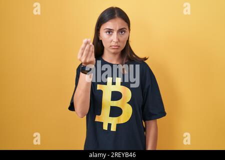 Jeune femme hispanique portant un t-shirt bitcoin faisant un geste italien avec la main et les doigts expression confiante Banque D'Images