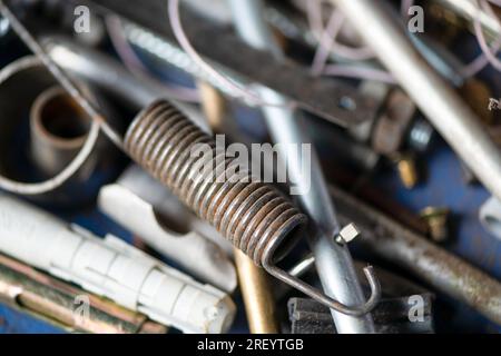 Boulons, rouages et autres pièces sont en désordre dans le garage, atelier de réparation. Fête de papa. Macrophotographie. Banque D'Images
