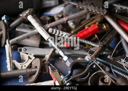 Boulons, rouages et autres pièces sont en désordre dans le garage, atelier de réparation. Fête de papa. Macrophotographie. Banque D'Images
