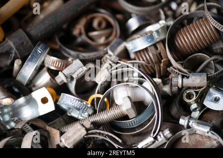 Boulons, rouages et autres pièces sont en désordre dans le garage, atelier de réparation. Fête de papa. Macrophotographie. Banque D'Images