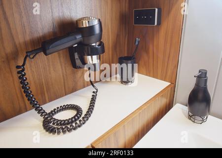 Les accessoires pour prendre un bain et se laver sont sur le lavabo blanc dans la salle de bain Banque D'Images
