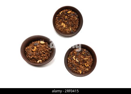 Céréales granola au chocolat avec noix dans un fond de bol.Isolé sur le background blanc. Banque D'Images