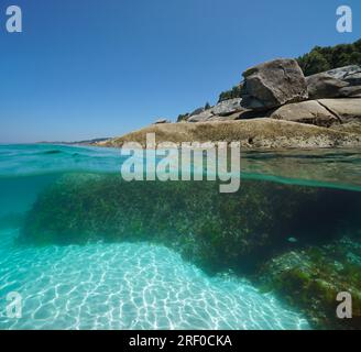 Rochers sur le rivage de la mer, vue partagée sur et sous la surface de l'eau, côte atlantique en Espagne, scène naturelle, Galice, Rias Baixas Banque D'Images