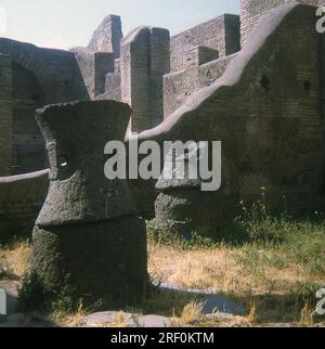 Pierres de moulin à grenier découvertes à Ostia Antica. Ostia Antica, située à l'embouchure du Tibre, était la ville portuaire de la Rome antique. On y trouve des mosaïques qui servaient de « signes de vitrine » pour les entreprises commerciales, principalement le transport maritime, les marchands de céréales, de toute la Méditerranée. C'était le principal centre pour le commerce et le commerce pour l'Empire romain principalement pendant l'âge d'Auguste (27 BC-31 AD). La photo date de 1970. Banque D'Images