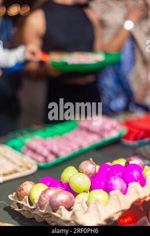 A côté de toute une variété colorée d'autres snacks, à un marché de nuit de nourriture à Dumaguete, près de la zone piétonne populaire et mur de mer, beaucoup de brochettes ke Banque D'Images