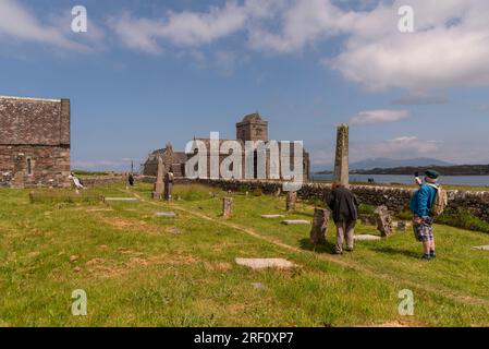 Île d'Iona, Argyll, Écosse, Royaume-Uni. 6 juin 2023. Touristes regardant l'abbaye d'Iona sur la côte de l'île d'Iona un lieu de pèlerinage et touristique att Banque D'Images