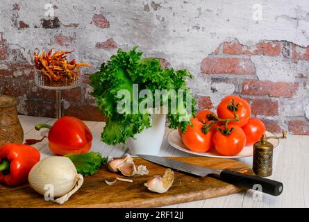 Nature morte avec tomates, oignons, ail, poivre et laitue Banque D'Images