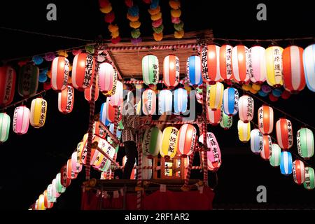 Yokohama, Japon. 29 juillet 2023. Le batteur joue du tambour taiko sur scène appelée Yagura entourée de lanternes décoratives dans un bon odori matsuri (festival d'été) au sanctuaire de Sugiyama. Après que le gouvernement japonais ait déclaré la fin de la pandémie de coronavirus en mai 2023, les fêtes estivales traditionnelles sont revenues dans les sanctuaires et les temples dans tout le pays. Crédit : SOPA Images Limited/Alamy Live News Banque D'Images