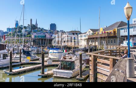 La vie vibrante de la marina de San Francisco est animée au premier plan tandis que l'emblématique horizon de la ville baigne dans la lueur chaude d'une journée ensoleillée en Californie. Banque D'Images