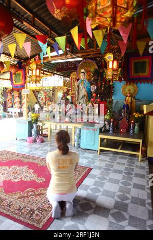 Dévot priant la déesse de la Miséricorde dans un temple local, Ho Chi Minh ville, Vietnam, Asie du Sud-est Banque D'Images