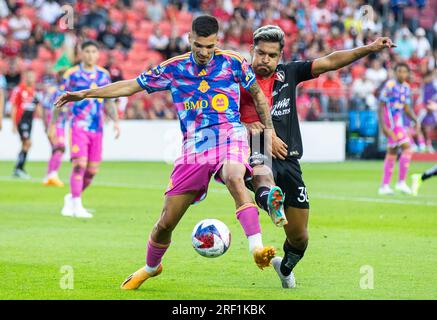 Toronto, Canada. 30 juillet 2023. Raoul Petretta (à gauche) de Toronto FC défie Eduardo Daniel Aguirre Lara d'Atlas FC lors du match de coupe des ligues 2023 entre Toronto FC et Atlas FC au BMO Field à Toronto, Canada, le 30 juillet 2023. Crédit : Zou Zheng/Xinhua/Alamy Live News Banque D'Images