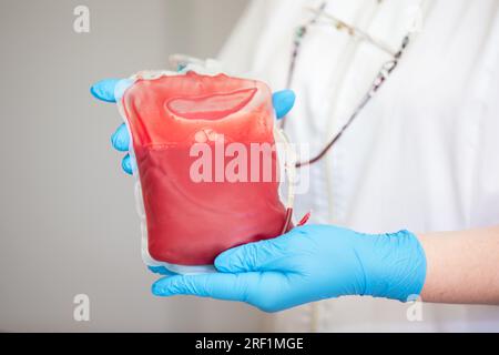 Le plasma sanguin au centre de la transfusiologie et du don. fermez la poche de sang dans le laboratoire dans les mains. Banque D'Images
