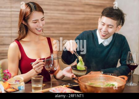 Heureux couple dînant dans le restaurant Hotpots Banque D'Images