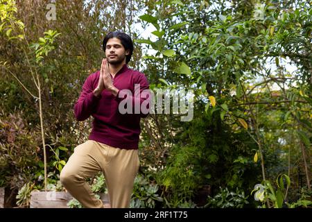 Homme indien concentré pratiquant le yoga dans une nature ensoleillée Banque D'Images
