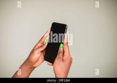 Mains tenant des gadgets de téléphone portable fonctionnant avec un écran d'espace vide au Kenya East Africa Electronics Banque D'Images