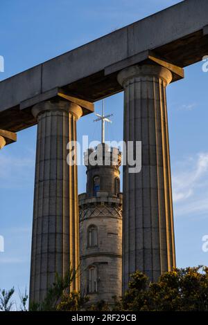 Nelson Monument encadré par des colonnes du National Monument of Scotland sur Calton Hill au coucher du soleil à Édimbourg, Écosse, Royaume-Uni. Banque D'Images