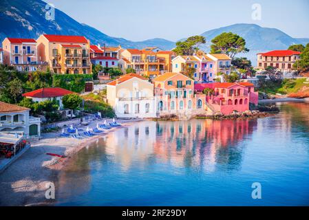 Assos, Grèce. Lever de soleil à Céphalonie, village pittoresque niché sur les îles Ioniennes idylliques. Belles maisons colorées et baie de couleur turquoise. Banque D'Images