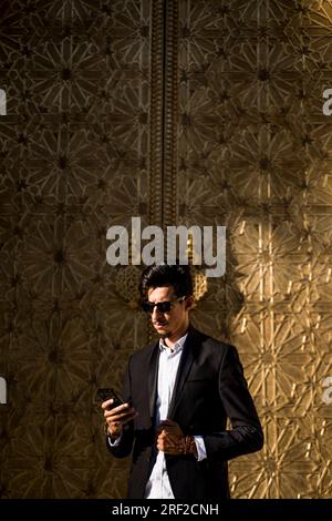 Homme marocain avec des lunettes de soleil et costume à côté du Palais Royal à Fe Banque D'Images