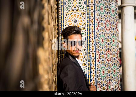 Homme marocain avec des lunettes de soleil et costume à côté du Palais Royal à Fe Banque D'Images