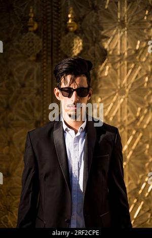 Homme marocain avec des lunettes de soleil et costume à côté du Palais Royal à Fe Banque D'Images