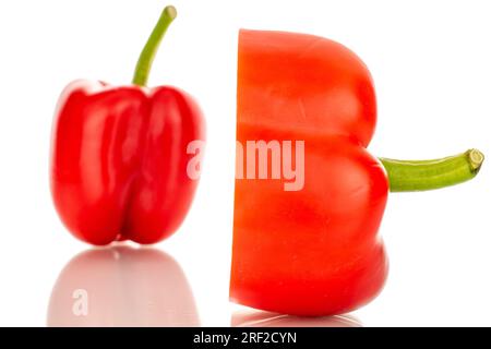 Un poivron rouge doux entier et demi, macro, isolé sur fond blanc. Banque D'Images