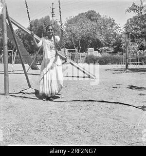 Vieux vintage des années 1900 photo noir et blanc de femme indienne sur balançoire enfants terrain de jeu Inde des années 1940 Banque D'Images