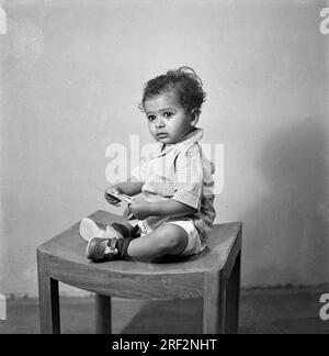 Vieux vintage des années 1900 noir et blanc portrait de studio de bébé garçon indien enfant assis tabouret Inde des années 1940 Banque D'Images