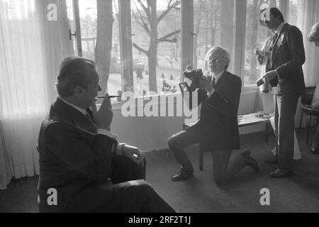 PHOTO D’ARCHIVE : Andy WARHOL aurait eu 95 ans le 6 août 2023, ART/politique Andy WARHOL(r.), USA, artiste, Représentation de l'ex-chancelier Willy BRANDT (SPD) avec une caméra instantanée. Warhol est agenouillé sur une jambe, tenant la caméra vers le haut, mais ne regarde pas à travers elle, semblant plutôt donner des instructions à Brandt. Brandt est assis sur une chaise et tient une cigarette avec un embout buccal dans sa main droite, demi-longueur de profil et plutôt silhouette, mais toujours reconnaissable. Warhol peut être vu en pleine longueur de l'avant. Photo noir et blanc, format paysage. ? Banque D'Images