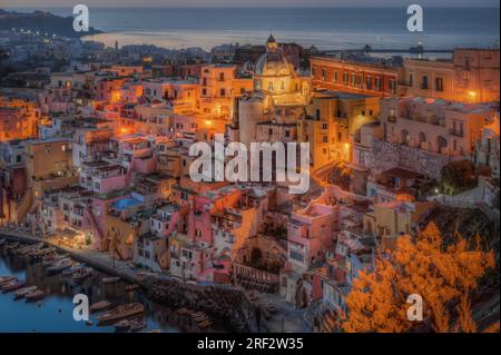 Vue panoramique rapprochée des maisons typiques de Corricella à Procida illuminées au coucher du soleil, Campanie, Italie Banque D'Images