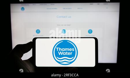 Personne tenant un téléphone portable avec le logo de la société britannique Thames Water Utilities Limited sur l'écran devant la page Web. Concentrez-vous sur l'affichage du téléphone. Banque D'Images