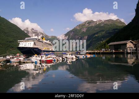 Bateau de croisière anglais amarré au village de Geiranger dans le fjord de Geiranger sur une belle journée de juillet avec des bateaux à moteur amarrés à la jetée Norvège Europe Banque D'Images