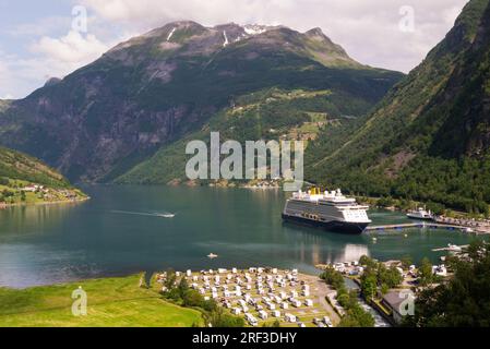 Vue vers le bas à Geirangerfjord de la cascade à pied avec bateau de croisière anglais amarré à Seawalk articulé jetée flottante Geiranger petit village touristique N Banque D'Images