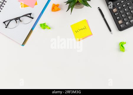 Fond blanc avec des fournitures scolaires, vue de dessus. Banque D'Images