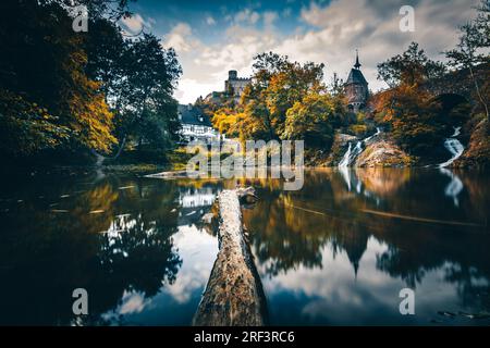 Moulin de Pyrmont en Rhénanie-Palatinat Allemagne Pont en pierre avec cascade un lac et maison à colombages. Un château en ruine en arrière-plan Banque D'Images