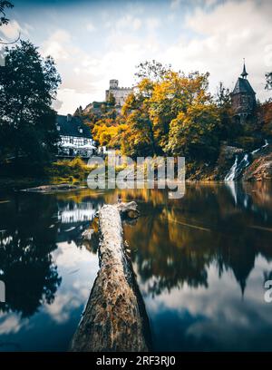 Moulin de Pyrmont en Rhénanie-Palatinat Allemagne Pont en pierre avec cascade un lac et maison à colombages. Un château en ruine en arrière-plan Banque D'Images
