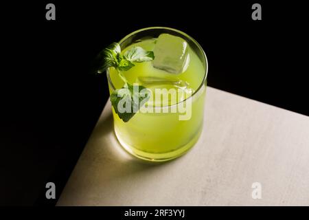 Gin Basil Smash cocktail booze le gin, le jus de citron, le sirop et les feuilles de basilic Banque D'Images