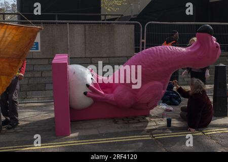 Londres, Royaume-Uni, 2023. Le jour de la Terre, un activiste met les dernières touches de peinture au dodo rose d'extinction Rebellion représentant les extinctions animales Banque D'Images