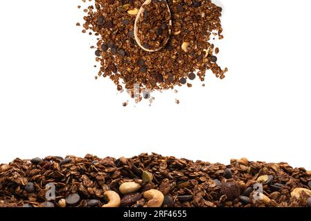 Céréales granola au chocolat avec noix dans une cuillère en bois.Isolé sur le background blanc. Banque D'Images