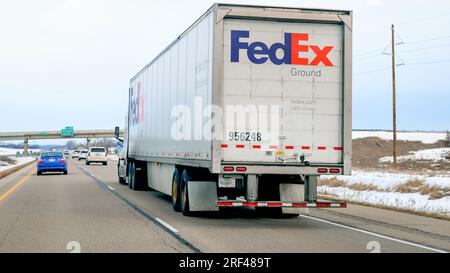 FARIBAULT, MN - 5 MARS 2023 : Fed ex semi Truck conduisant sur Freeway, vu à travers un pare-brise de voiture lors d'une journée nuageuse. Banque D'Images