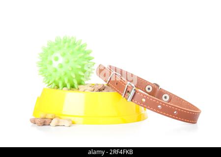 Bol de nourriture sèche pour animaux de compagnie, collier et boule de jouet sur fond blanc Banque D'Images