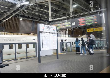 Takeo Onsen, Préfecture de Saga, Japon. 11 mars 2023. Passagers en transfert vers le nouveau train à grande vitesse Nishi-Kyushu Shinkansen (è¥¿ä¹å·žæ-°å¹¹ç·š), qui offre des services ferroviaires à grande vitesse de Takeo-Onsen à Nagasaki, exploité par la compagnie ferroviaire Kyushu (JR Kyushu JRä¹å·ž). En raison des objections du gouvernement préfectoral local de Saga, Le service ne dessert pas directement la gare de Hakata à Fukuoka et est relié au réseau national Shinkansen par un train express limité ''Relay Kamome'' plus lent jusqu'à la rame ''Kamome'' N700S. Les passagers interurbains doivent effectuer un transfert inter-plateforme dans la rura Banque D'Images