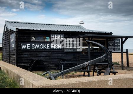 Fumoir de poisson traditionnel sur la plage de galets dans la ville balnéaire touristique d'Aldeburgh sur la côte du Suffolk, Angleterre, Royaume-Uni Banque D'Images