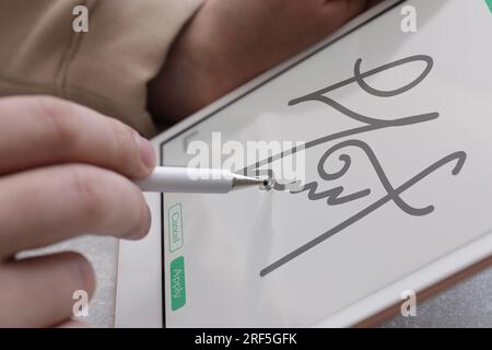 Signature électronique. Homme utilisant stylet et tablette, gros plan Banque D'Images